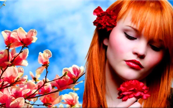 A portrait of a redhead woman model against a backdrop of vibrant blue skies and blossoming flowers, creating a striking HD desktop wallpaper.