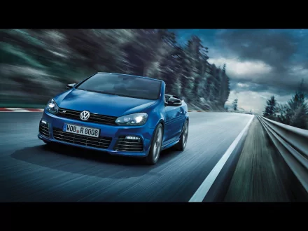 Blue 2013 Volkswagen Golf R Cabriolet driving on a winding road with a blurred forest background, featured as an HD PC desktop wallpaper and background.