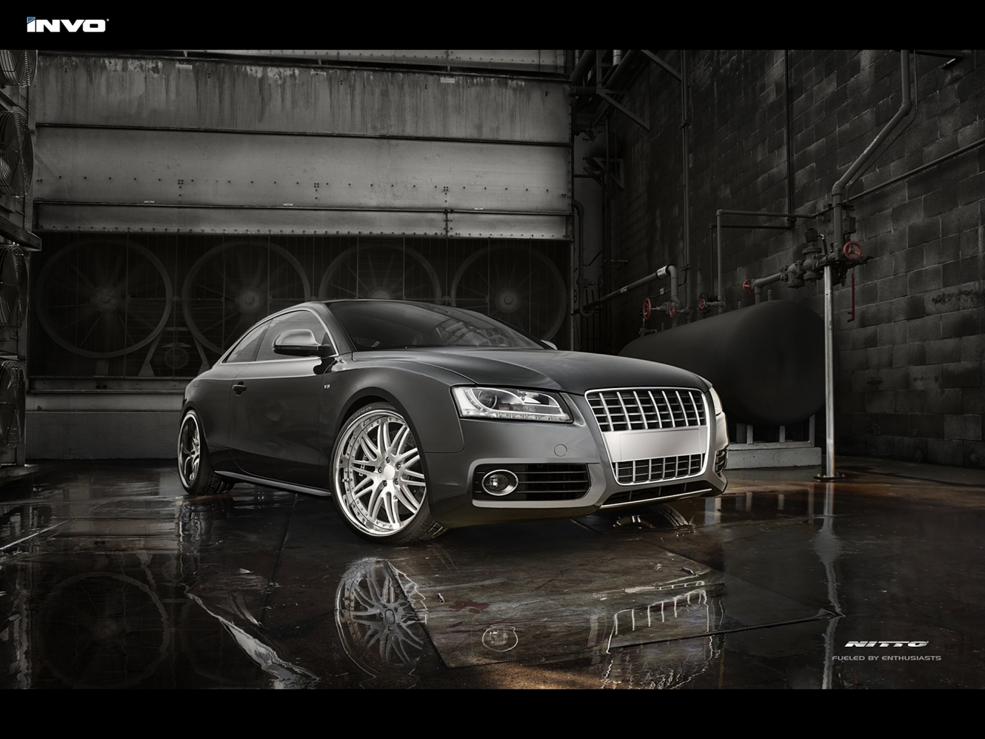 HD desktop wallpaper featuring a sleek Audi S5 parked in an industrial, dimly lit setting with reflective wet floor surfaces.