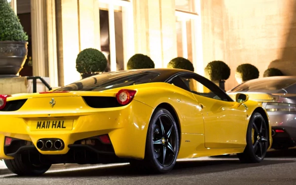 HD desktop wallpaper featuring a vibrant yellow Ferrari 458 Italia parked on a city street at night.