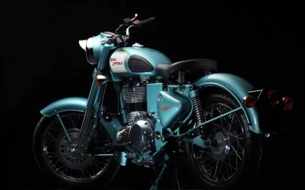 A Royal Enfield Bullet 500 motorcycle, featuring a striking blue color, showcased against a dark background. This high-definition image serves as a captivating desktop wallpaper.
