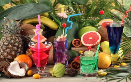 HD desktop wallpaper featuring an assortment of colorful tropical cocktails surrounded by fresh fruits like pineapple, coconut, grapefruit, and bananas.