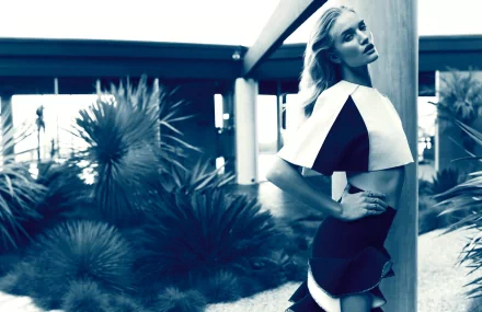 HD desktop wallpaper featuring celebrity Rosie Huntington-Whiteley posing outdoors with modern architectural elements and lush greenery in the background.