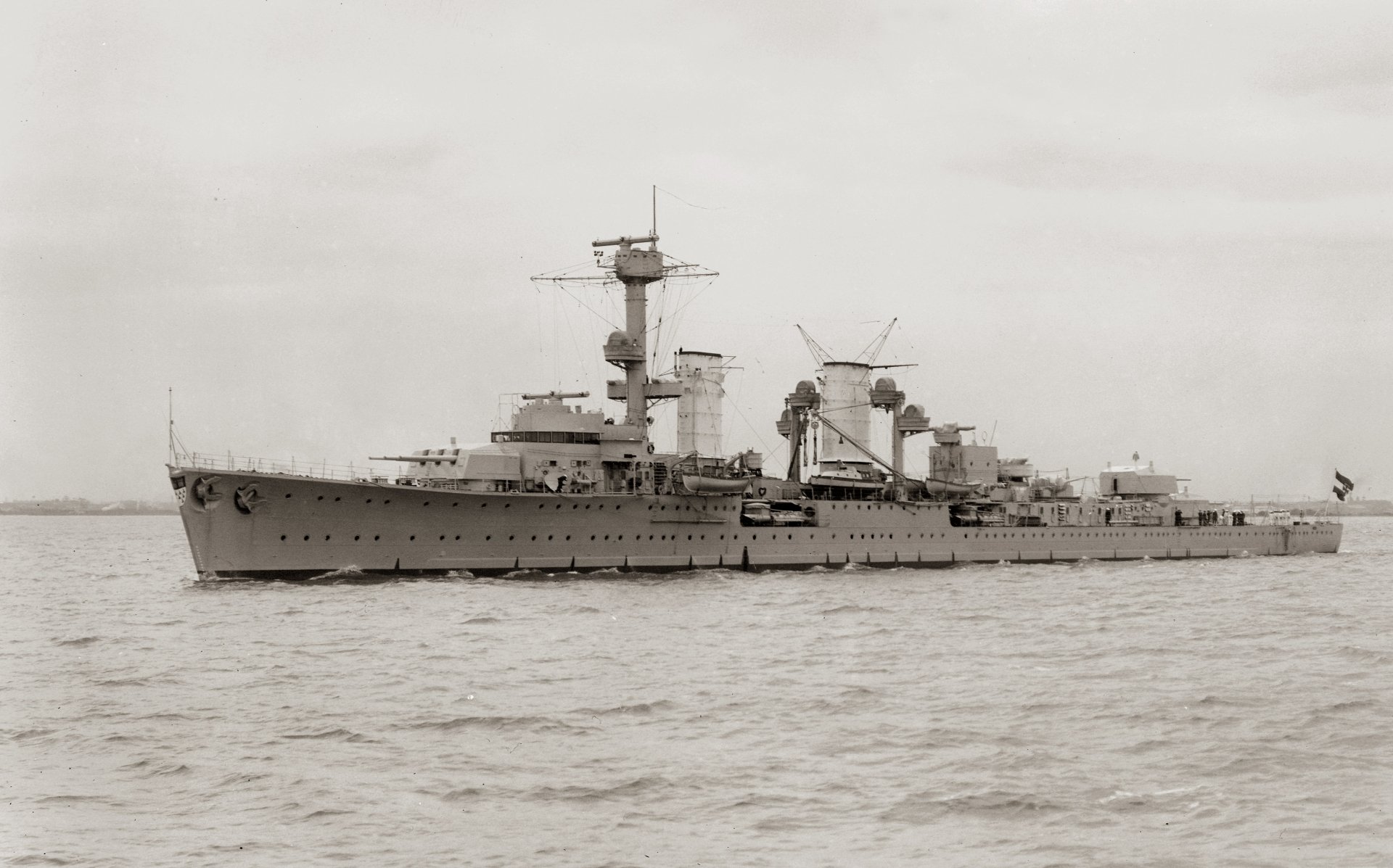 4K Ultra HD wallpaper featuring a historic military battleship cruising on calm waters under an overcast sky.