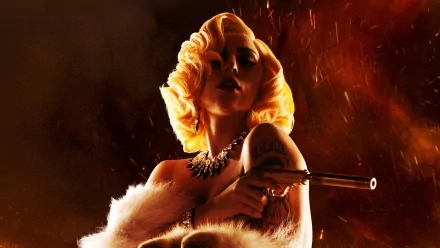 A striking HD wallpaper featuring Lady Gaga, exuding confidence and allure with a glamorous hairstyle and a fierce pose, set against a dramatic, fiery background.
