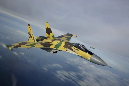 A Sukhoi Su-35 military aircraft flies through a cloudy sky, showcasing its striking camouflage design in a high-definition wallpaper background.