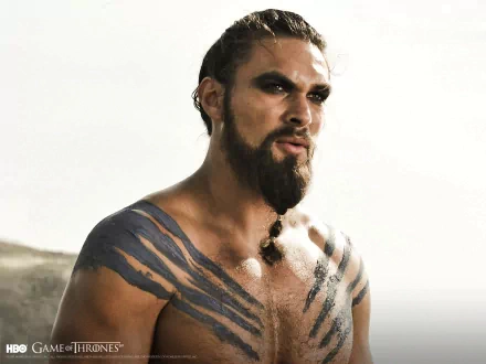 HD wallpaper featuring Jason Momoa as Drogo from Game of Thrones, showcasing his striking tattoos and intense expression against a dramatic backdrop.