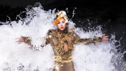 HD PC desktop wallpaper featuring Lady Gaga in a dramatic gold outfit with water splash effects, highlighting her iconic presence in music.