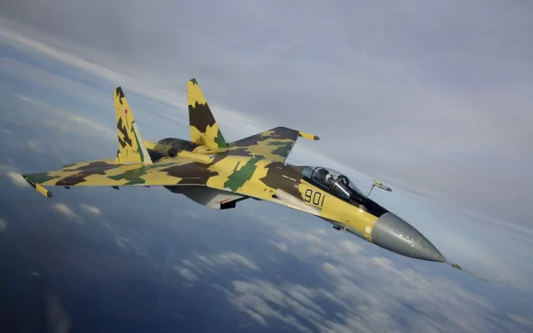 A Sukhoi Su-35 military aircraft flies through a cloudy sky, showcasing its striking camouflage design in a high-definition wallpaper background.