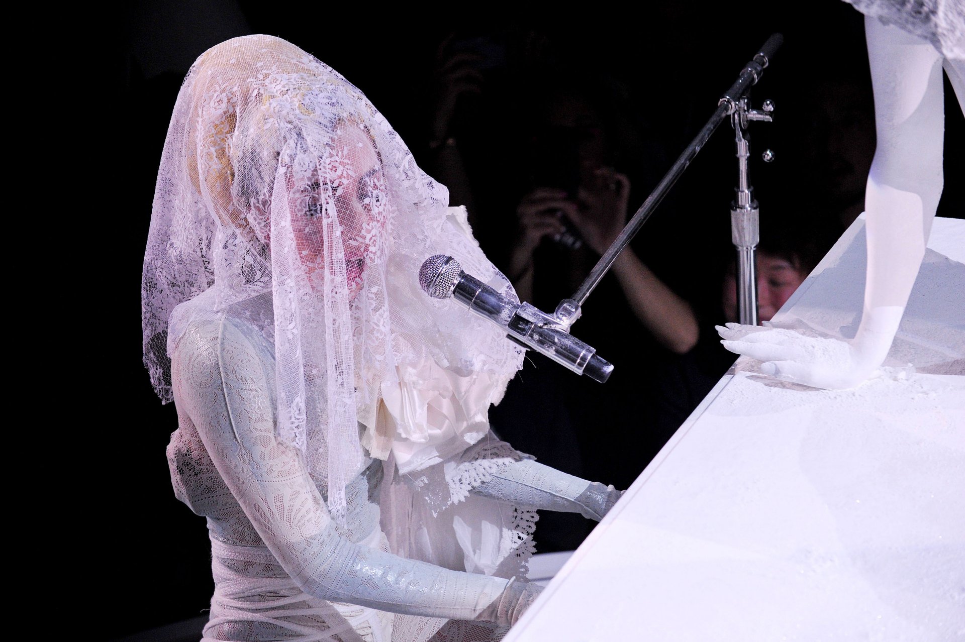 Lady Gaga performs at a piano, draped in an intricate lace veil, captured in an HD music-themed PC desktop wallpaper.