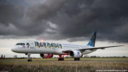 A Boeing 757 adorned with Iron Maiden graphics taxis on an airstrip, set against a moody sky, making for a striking HD desktop wallpaper and background.