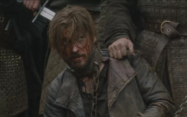 HD PC desktop wallpaper: bloodied, chained man kneels amid armored soldiers in a gritty medieval fantasy TV show scene.