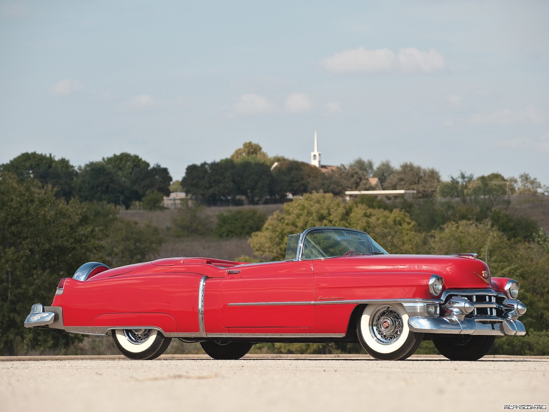 Red 1953 Cadillac Eldorado convertible parked outdoors, showcased as an HD PC desktop wallpaper and background with clear skies and greenery in the background.