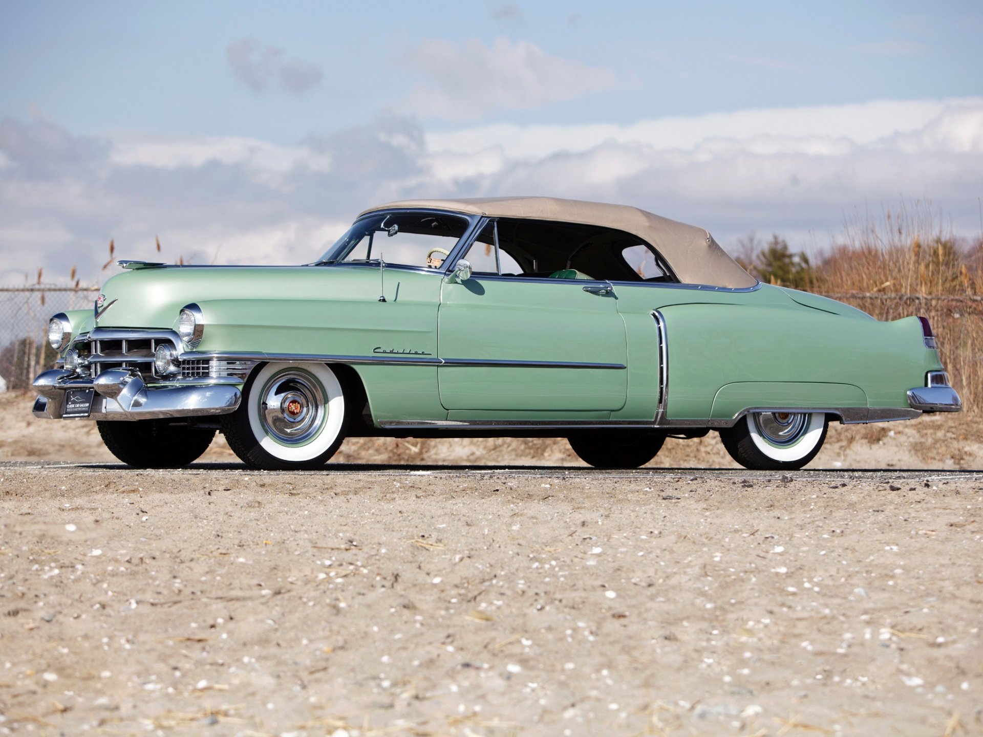Classic vehicle: mint-green Cadillac Sixty-Two convertible on a sandy shore beneath a cloudy sky — HD PC desktop wallpaper/background.