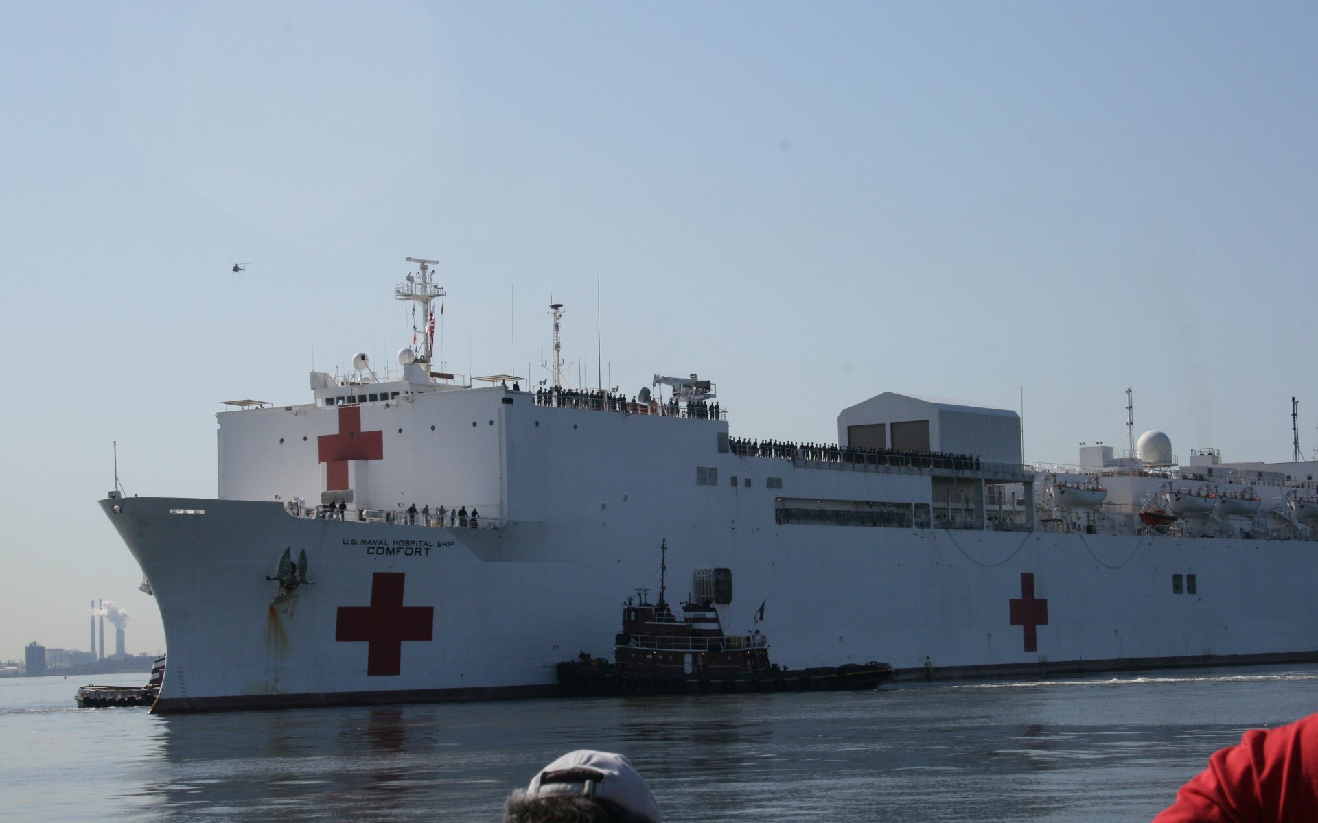 4K Ultra HD image of the USNS Comfort (T-AH-20), a military hospital ship and warship, docked calmly under clear skies.