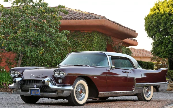 A 1958 Cadillac Eldorado Brougham with a two-tone maroon and white exterior parked in front of a residential building, featured as an HD PC desktop wallpaper.