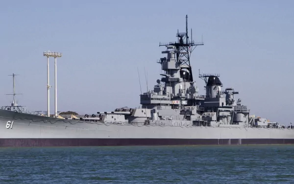 A majestic view of the USS Iowa (BB-61), a historical battleship, captured in high definition, showcasing its military design against a clear blue sky.