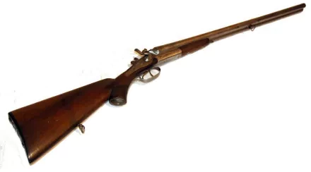 HD desktop wallpaper featuring a detailed man-made antique shotgun with a wooden stock and metal barrel on a white background.