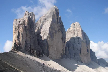 HD PC desktop wallpaper background of nature: Tre Cime di Lavaredo's sunlit limestone peaks rising against a bright blue sky.