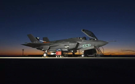 A Lockheed Martin F-35 Lightning II stands on the tarmac under a twilight sky, showcasing its sleek design and advanced technology. This HD image serves as a striking military-themed desktop wallpaper.