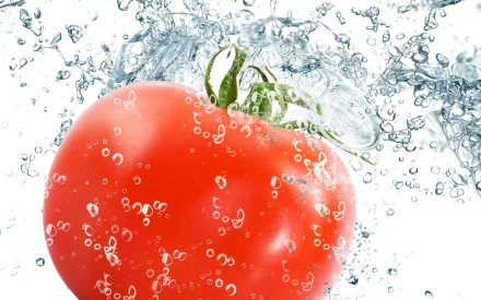 HD PC desktop wallpaper featuring a vibrant red tomato submerged in sparkling water with bubbles, highlighting freshness and food elements.