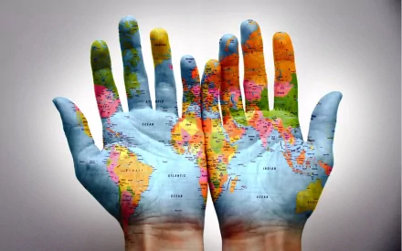 Two hands with the world map painted on them, presented as a high-definition desktop wallpaper and background.