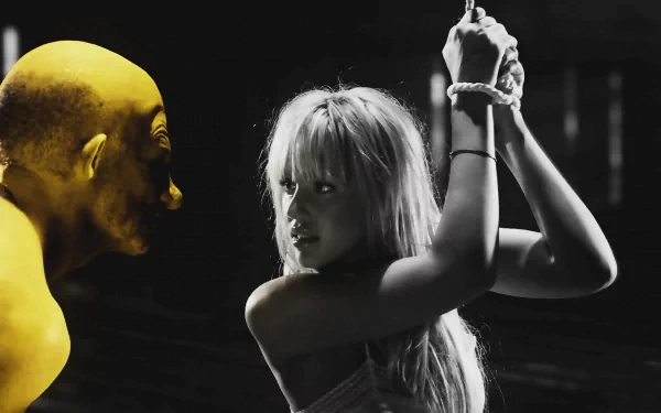 HD PC desktop wallpaper: stylized Sin City movie scene — high-contrast black-and-white woman bound with wrists raised, tense stare as a yellow-tinted bald figure looms.