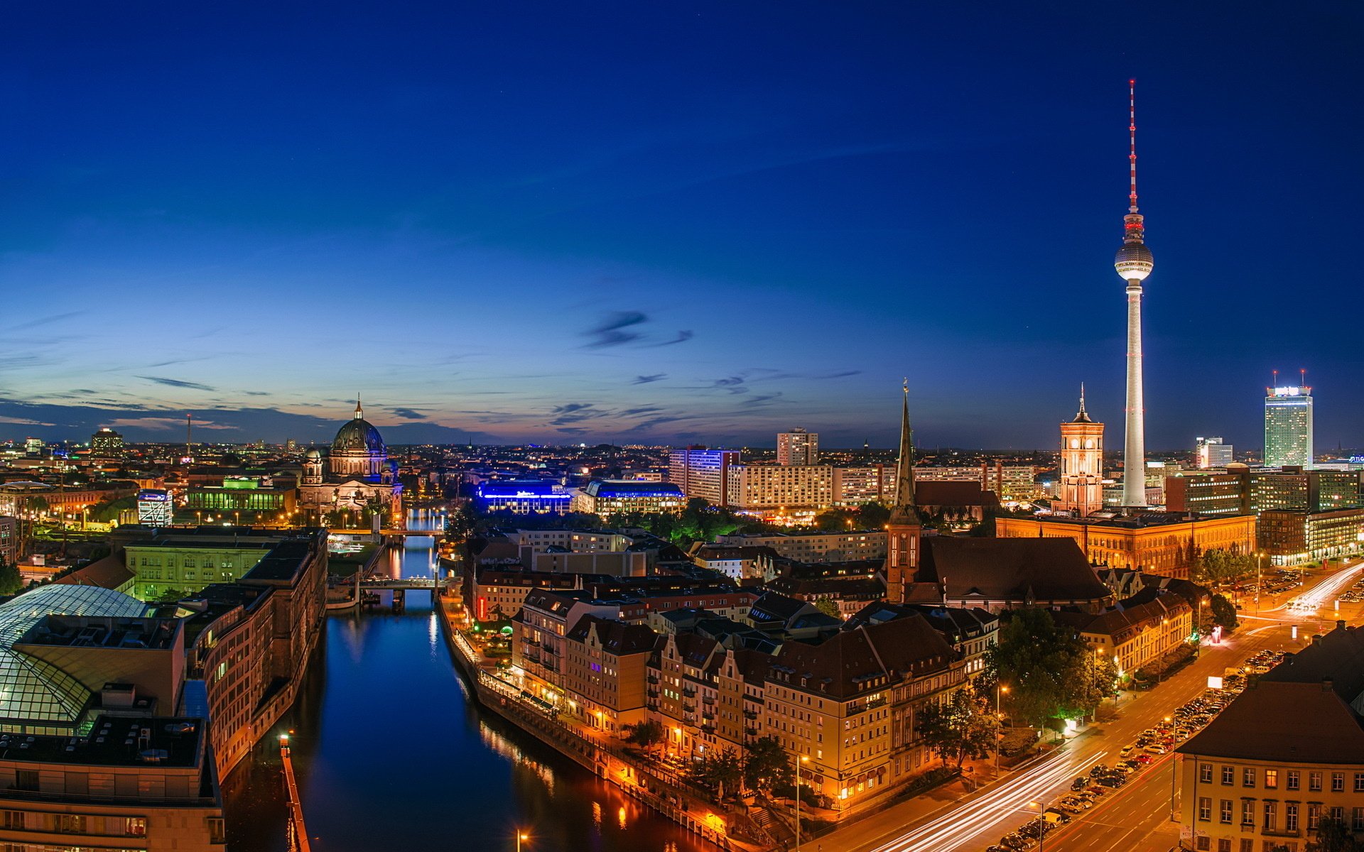 Night aerial view of Berlin, Germany showing man-made skyline and the illuminated Fernsehturm reflected on the river — HD PC desktop wallpaper and background.
