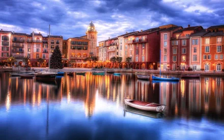 HD desktop wallpaper of a vibrant man-made town with colorful buildings reflected in calm water under a dramatic cloudy sky, featuring small boats anchored nearby.