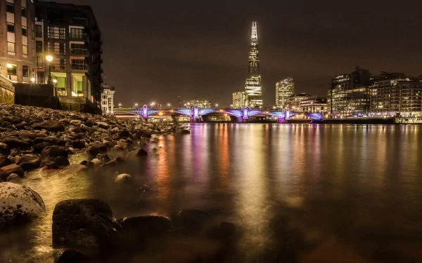 London night skyline with The Shard and illuminated Southwark Bridge reflected on the Thames — man made architecture captured as an HD PC desktop wallpaper background.