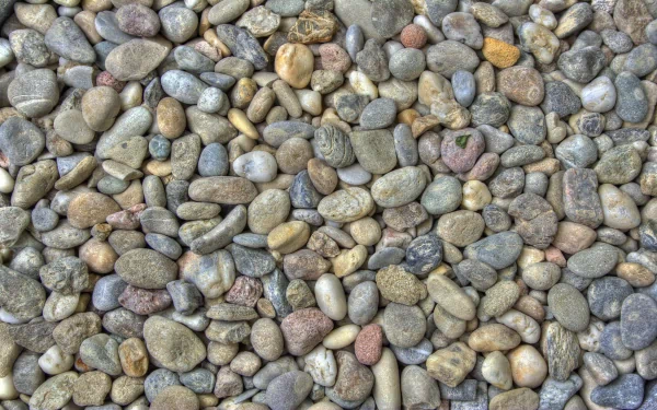 Nature stone texture of smooth multicolored river pebbles, 2K Quad HD PC desktop wallpaper and background.