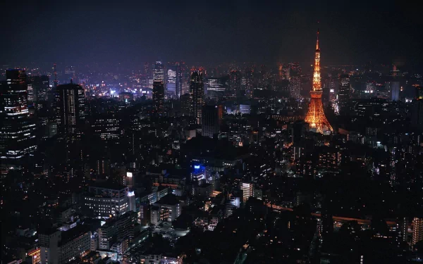 Nighttime cityscape of Tokyo, Japan, featuring the illuminated Tokyo Tower standing tall among surrounding buildings in this HD desktop wallpaper.