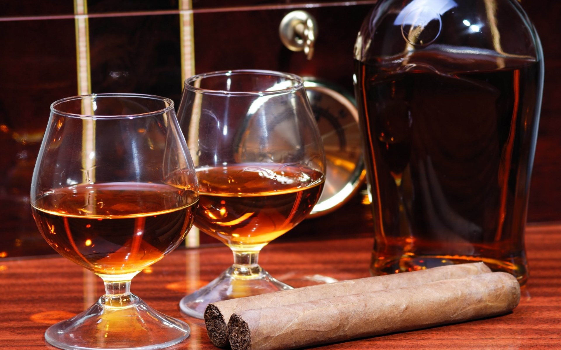 A sophisticated display of whisky in two glasses beside a cigar, set against a rich wooden background, creating an inviting atmosphere for relaxation.