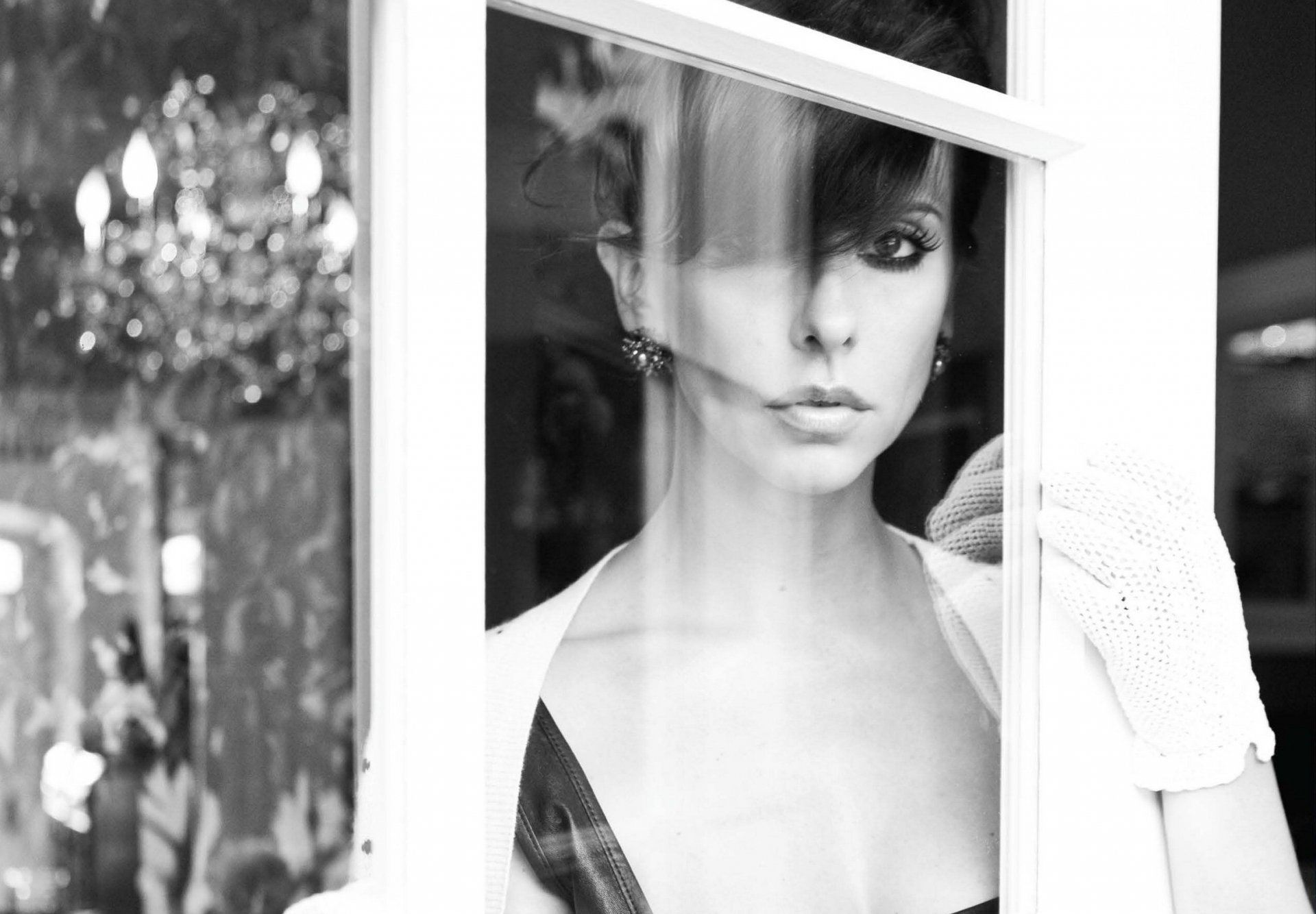A striking black-and-white HD wallpaper features Jennifer Love Hewitt gazing intently through a window, exuding elegance and mystery.
