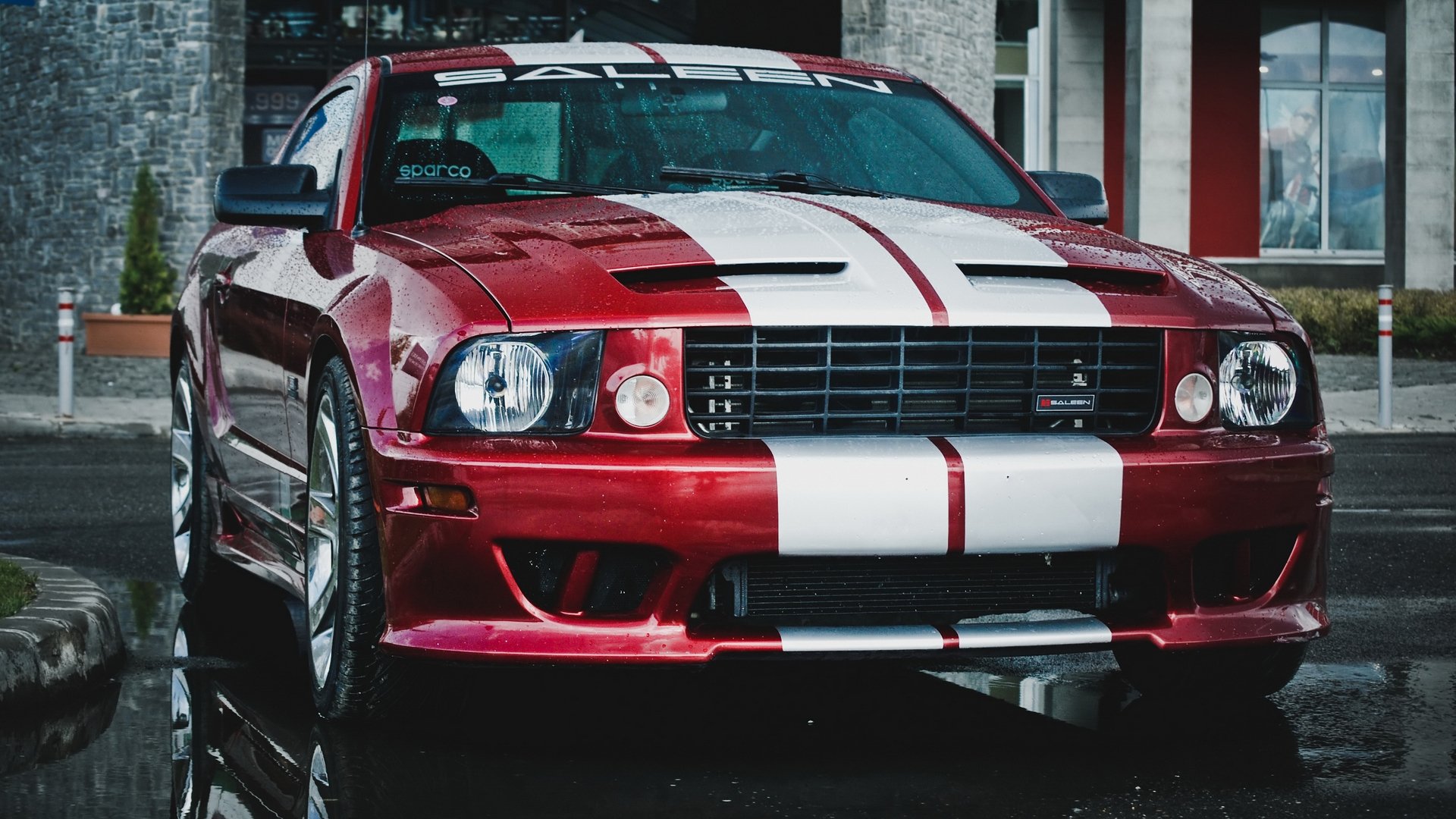 A striking red Ford Mustang with white racing stripes, showcasing its sleek design and sporty aesthetics, makes for an impressive HD PC desktop wallpaper and background.