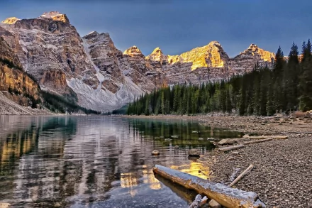 A tranquil nature scene featuring majestic mountains reflecting in calm lake waters, surrounded by evergreen trees, captured in vibrant, high-definition detail.