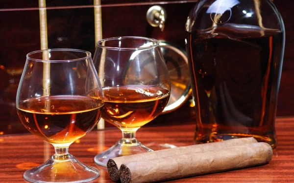 A sophisticated display of whisky in two glasses beside a cigar, set against a rich wooden background, creating an inviting atmosphere for relaxation.