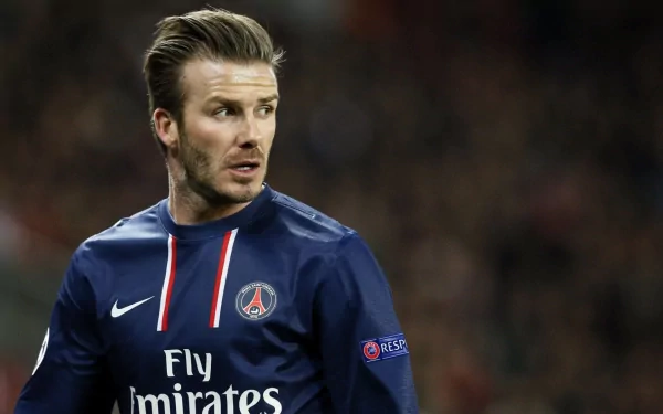 HD desktop wallpaper featuring David Beckham in a Paris Saint-Germain football kit during a match, capturing a focused sports moment.