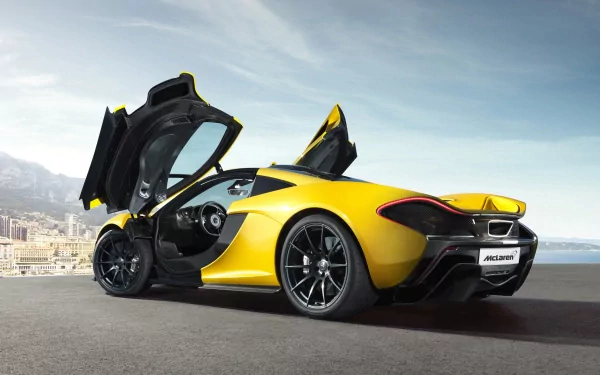 HD wallpaper featuring a yellow McLaren P1 supercar, showcasing its sleek design with butterfly doors open, against a scenic coastal backdrop.