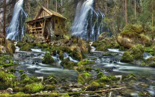 HD desktop wallpaper featuring a serene man-made watermill by cascading waterfalls surrounded by lush forest and moss-covered rocks.