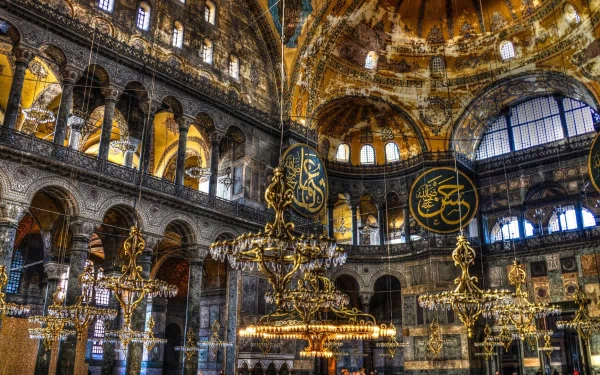 Stunning HD wallpaper showcasing the interior of Hagia Sophia, featuring intricate architecture, grand chandeliers, and beautiful mosaics, reflecting its rich religious heritage.