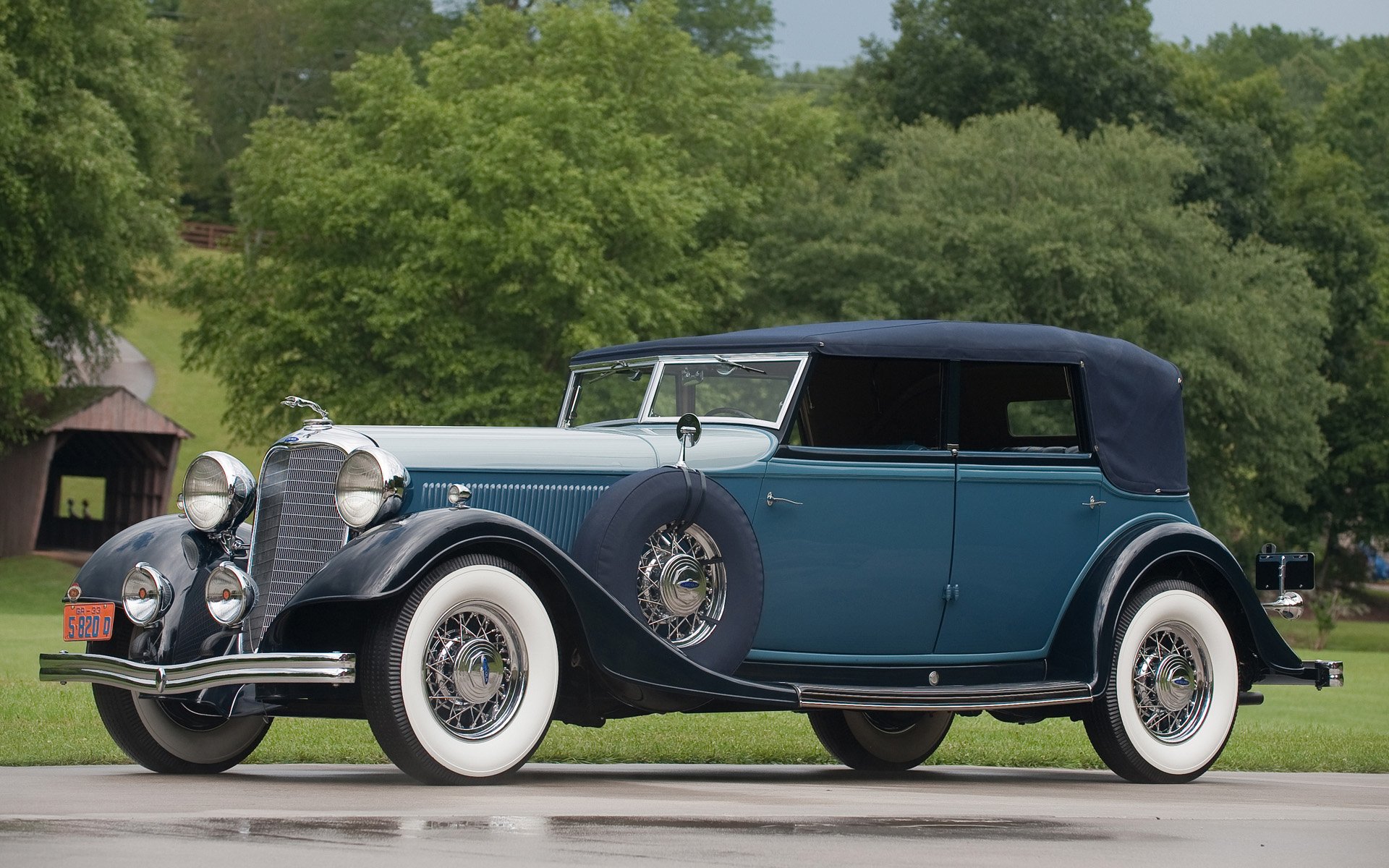 HD wallpaper of a classic 1932 Lincoln 4 Door Convertible KB V12, showcasing its vintage elegance against a lush green backdrop.