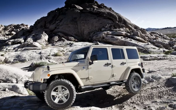 A Jeep Wrangler parked on rugged terrain, showcasing its off-road capabilities against a backdrop of rocky formations. High-definition PC desktop wallpaper.