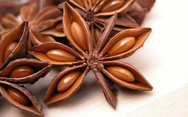 Close-up of star anise pods, showcasing their unique star shape and brown seeds. A vibrant addition to any food-themed 4K Ultra HD wallpaper or desktop background.
