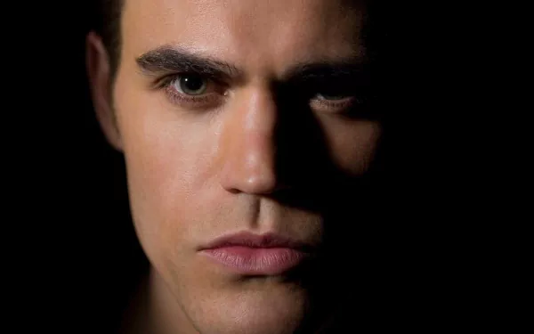 Close-up HD desktop wallpaper of celebrity Paul Wesley with intense gaze and dramatic lighting on his face.
