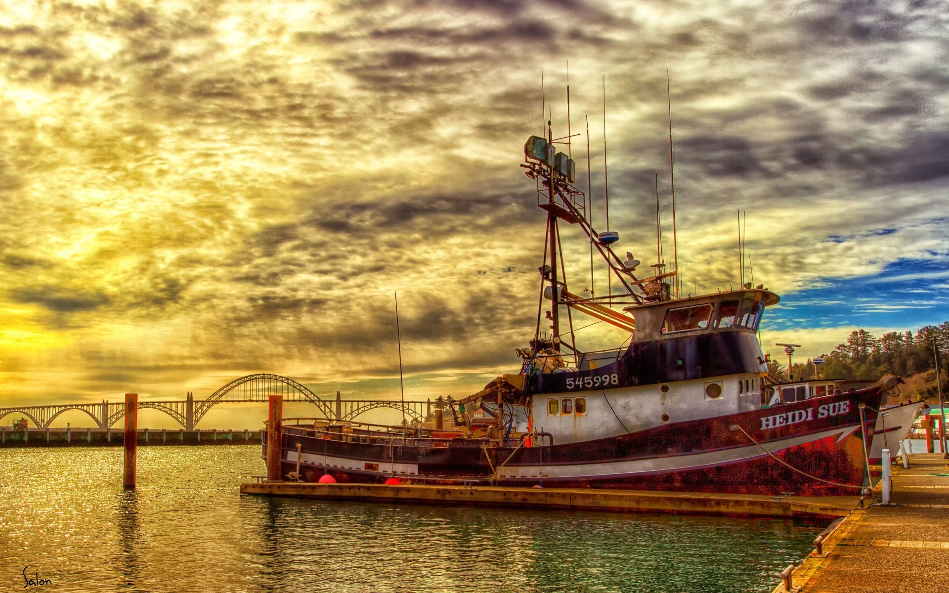 HD PC desktop wallpaper showing a boat docked by the pier under a dramatic cloudy sky with a bridge in the background.