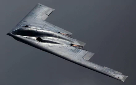 A Northrop Grumman B-2 Spirit aircraft soars through the sky, showcasing its stealthy design and military capabilities. This HD image serves as a striking desktop wallpaper.
