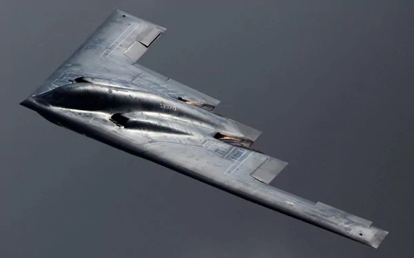 A Northrop Grumman B-2 Spirit aircraft soars through the sky, showcasing its stealthy design and military capabilities. This HD image serves as a striking desktop wallpaper.