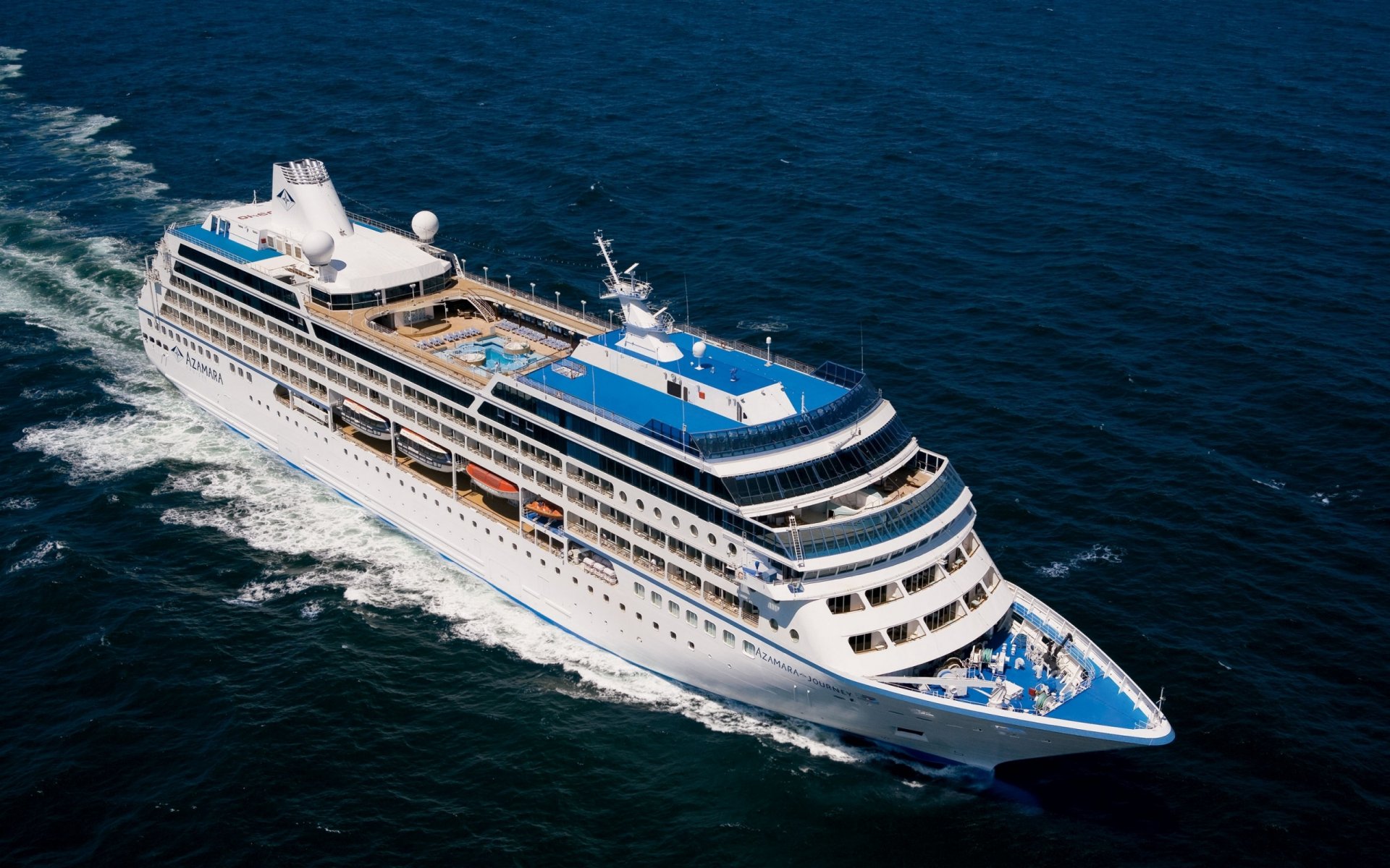 Aerial view of the Azamara Journey cruise ship sailing through deep blue ocean waters, captured as an HD PC desktop wallpaper and background.