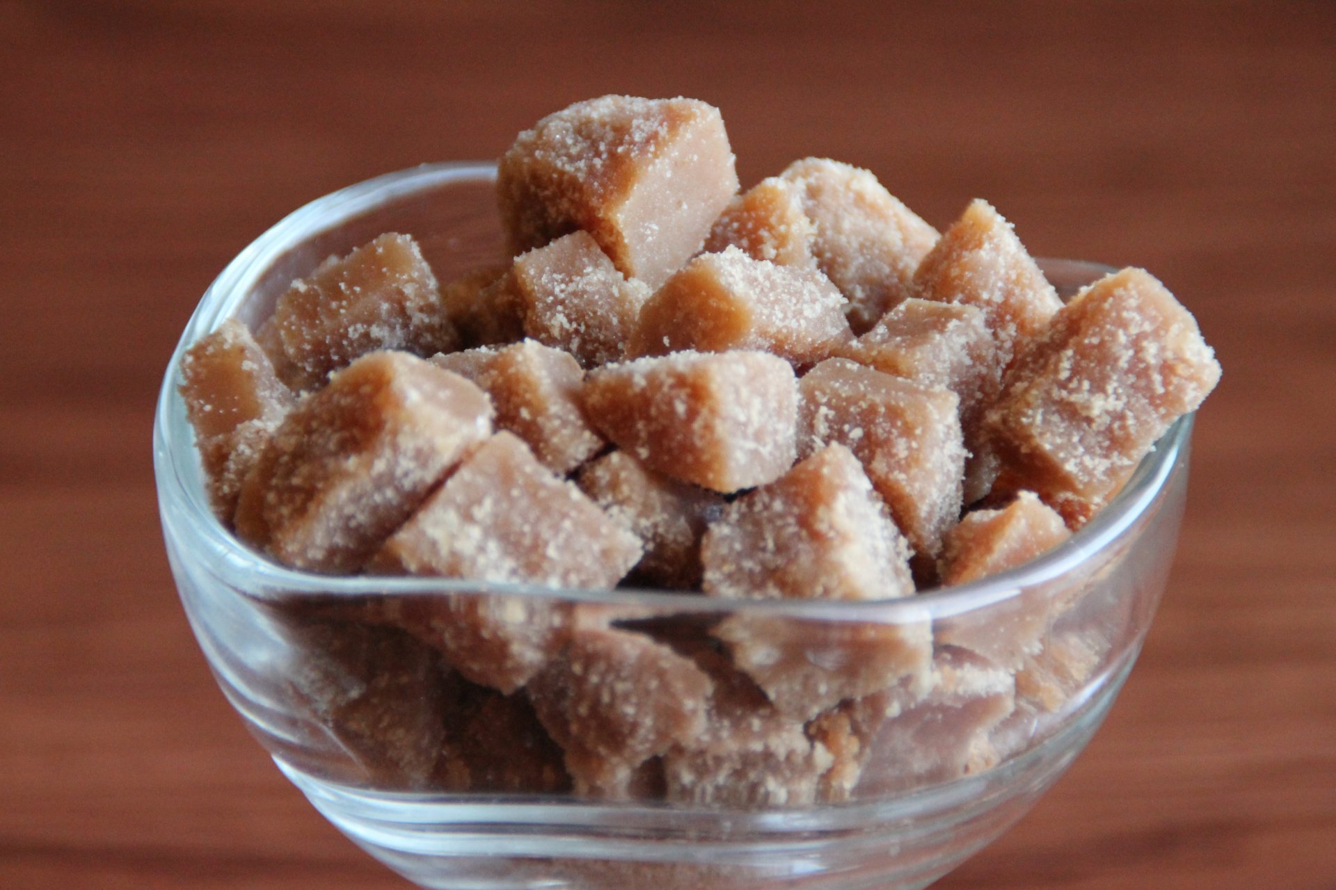Close-up of crystallized brown sugar cubes in a glass bowl, captured in 4K Ultra HD as a vibrant PC desktop wallpaper featuring food and sweets.